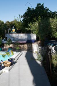 a shady walkway with a fountain in a garden at Inn 4 Bears in Nîmes