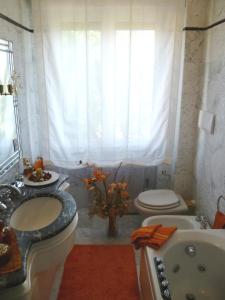 a bathroom with a sink and a toilet and a tub at Villa Casa Gemelli in Capolona