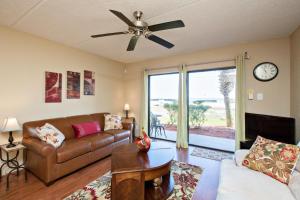 a living room with a couch and a ceiling fan at Ocean Watch Condo Unit #105 in Ormond Beach