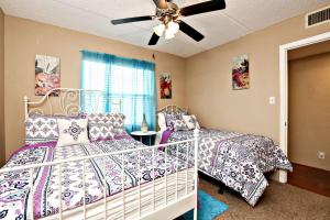 a bedroom with two beds and a ceiling fan at Ocean Watch Condo Unit #105 in Ormond Beach +26 photos