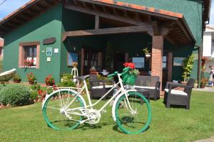 a white bike parked in the grass in front of a house at El Rincón del Oteru in Llanes