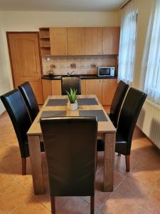 jadalnia ze stołem i czarnymi krzesłami w obiekcie Váralja Vendégház w mieście Tata