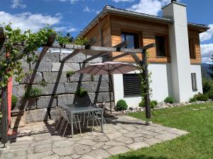 einen Tisch und einen Regenschirm vor einem Haus in der Unterkunft Mira Selva in Trin