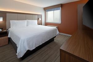 a hotel room with a bed and a flat screen tv at Holiday Inn Express Seattle - Sea-Tac Airport, an IHG Hotel in SeaTac