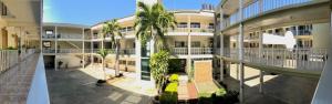 an apartment building with palm trees in the courtyard at Hotel del Camino Real in El Grullo