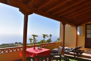 a table on the balcony of a house at Casa Rosa in Tijarafe