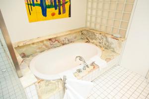 een badkamer met een ligbad en een wastafel bij Brauhaus Breznik in Bleiburg