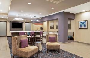 a lobby with a bar and a dining room at La Quinta by Wyndham Fayetteville in Fayetteville