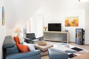 ein Wohnzimmer mit einem blauen Sofa und einem TV in der Unterkunft DÜNE-9 in Dierhagen-Strand in Dierhagen