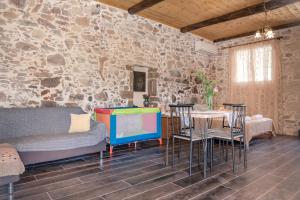 a room with a table and chairs and a stone wall at The Stone House of Iakovos in Kaloudhianá