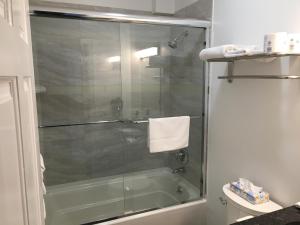 ein Bad mit einer Dusche und einer Glastür in der Unterkunft Rhea's Inn by the Sea in Middletown