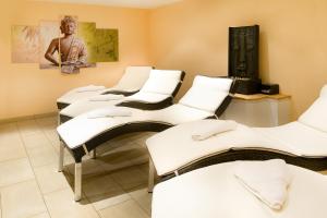 Ferienhotel Elvira في تيرسي: غرفه فيها مجموعه من الكراسي البيضاء