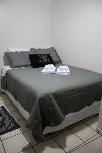 a bed with two towels on top of it at Apto Residencial Saguaçu in Joinville