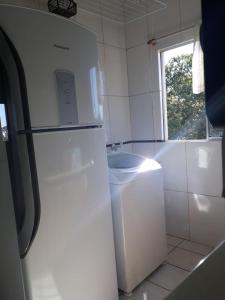 a kitchen with a white refrigerator and a sink at Apto Residencial Saguaçu in Joinville