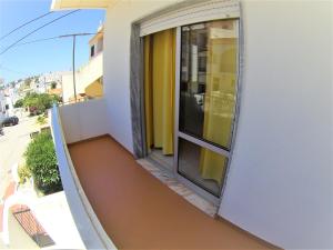 - Balcón de un edificio con ventana en Apartamentos Turisticos Praia Grande, en Ferragudo