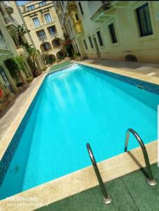Apartment With Pool Gozo في غاينسييليم: مسبح ازرق كبير امام مبنى