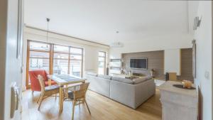 een woonkamer met een bank en een tafel bij Apartament Nadmorski Piasek in Gdańsk