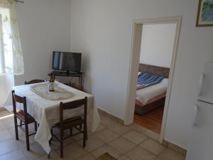 a small dining room with a table and a mirror at Apartments Jovanović in Perast