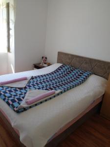 a bed with a blanket on top of it at Apartments Jovanović in Perast