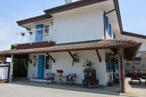 a house with a balcony and a table and chairs at Villa Roma Holidays in Jesolo