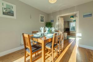 a dining room with a wooden table and chairs at Wigeon Watch in Uny Lelant