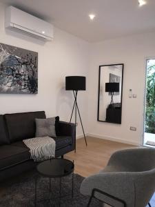 a living room with a black couch and a chair at Apartments Antoana in Hvar