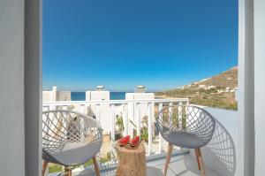a balcony with two chairs and a view of the ocean at Akrolithos studios in Stelida