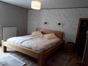 1 dormitorio con 1 cama con edredón blanco en CHAMBRES D'HOTES au vieux moulin entre Sarreguemine et Bitche, en Rahling