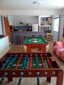 a living room with a pool table with bats on it at Pousada Girassol in Rio das Ostras