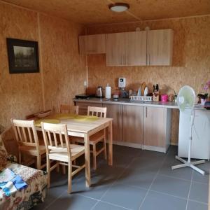 uma cozinha com uma mesa e cadeiras numa cozinha em Eurostruś - zoo, domki em Borzychy