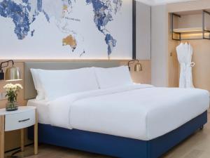 a bedroom with a large bed with a world map on the wall at Shenzhen Universide-Senter＆BaoHe Road Kyriad Marvelous Hotel in Shenzhen