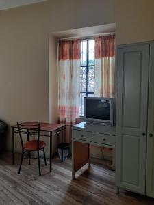 a room with a desk with a tv and a table at Hostal Mediodia in Quito