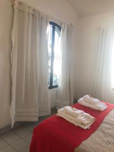 2 toallas en una cama en una habitación con ventana en Cálido apartamento en Salta