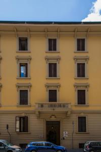 ein gelbes Gebäude mit davor geparkt in der Unterkunft Hotel Angelica " Stazione Santa Maria Novella " in Florenz