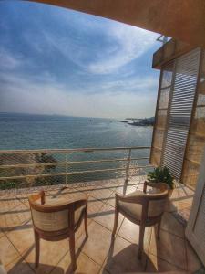 a balcony with two chairs and a view of the ocean at Pousada Pedra das Tartarugas in São Francisco do Sul