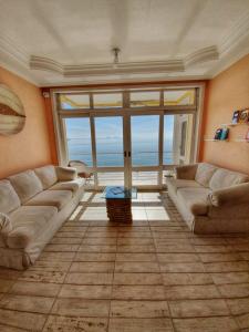 a living room with two couches and a view of the ocean at Pousada Pedra das Tartarugas in São Francisco do Sul