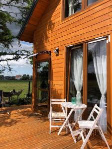 patio z 2 krzesłami i stołem na tarasie w obiekcie Zamieszkaj na wsi blisko Warszawy w mieście Borucza