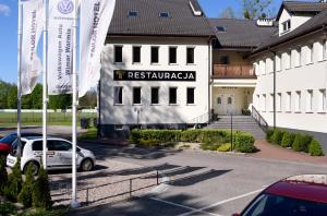 um edifício com um carro estacionado num parque de estacionamento em Tailor Hotel Sport & Conference em Morąg