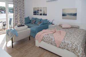 a bedroom with a bed and a blue couch at Apartment Gordon in Mali Lošinj