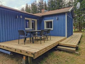 a deck with a table and chairs on a tiny house at Hyltenäs am Kalvsee in Kalv