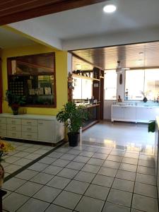 a large kitchen with yellow walls and white cabinets at Pousada Girassol in Rio das Ostras