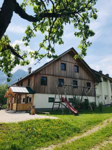 a barn with a slide and a playground at Strauss Appartements in St. Wolfgang