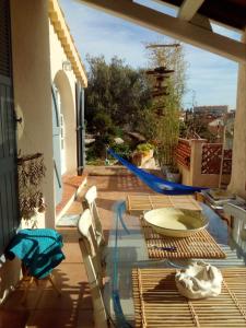 d'une terrasse avec une table en verre et des chaises sur un balcon. dans l'établissement Maison de 2 chambres avec jardin clos et wifi a Toulon a 4 km de la plage, à Toulon