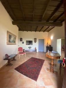 ein großes Wohnzimmer mit einem Tisch und einem Teppich in der Unterkunft Antico Casale Edifizio in Viterbo