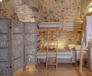 um quarto com 2 beliches num quarto de pedra em Azura, traditional residence in Ano Syros em Ano Syros