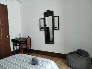 1 dormitorio con cama y espejo en la pared en Quarto & Pasta Guesthouse en Coimbra