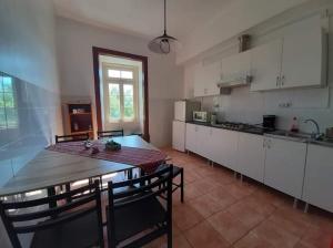 eine Küche mit einem Tisch und Stühlen sowie einem Tisch und einem Tisch und einer Küche in der Unterkunft Quarto & Pasta Guesthouse in Coimbra