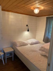 a bedroom with a bed and a lamp at Nygård Camping in Hjelle