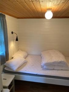 a bedroom with a bed and a lamp on the wall at Nygård Camping in Hjelle