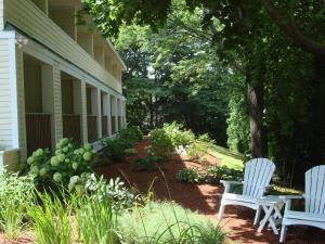 two white chairs sitting on the side of a house at The Grand Hotel in Ogunquit